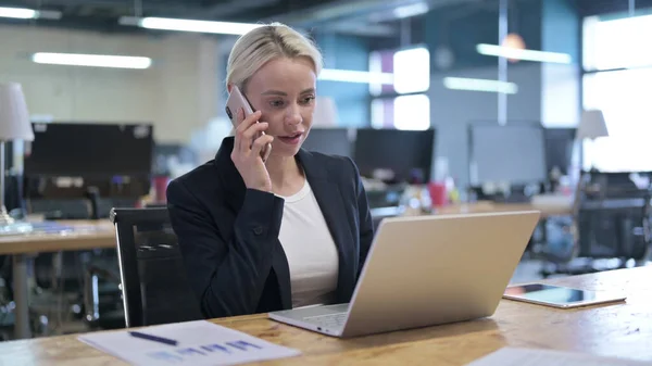 Vrolijke zakenvrouw praten op Smartphone op het werk — Stockfoto