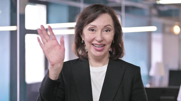 Portrait of Cheerful Old Businesswoman Waving at Camera and Welcoming