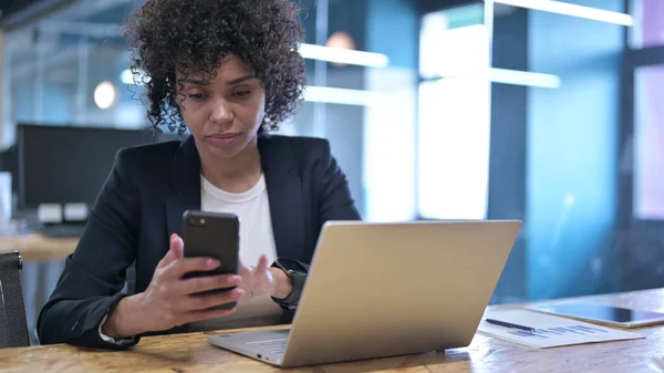 Empresária séria usando Smartphone no trabalho — Fotografia de Stock