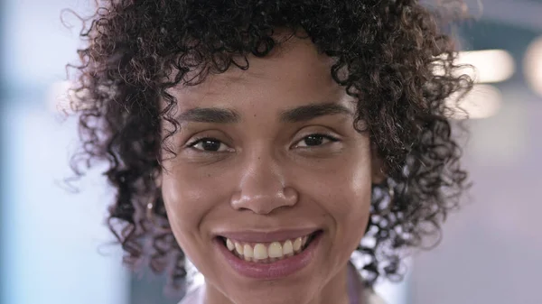 Nahaufnahme einer schönen jungen Afrikanerin, die in die Kamera blickt und lächelt — Stockfoto
