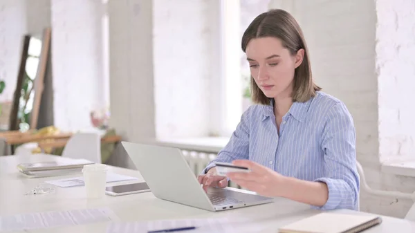 Femme gaie effectuant le paiement en ligne par carte de crédit au bureau — Photo