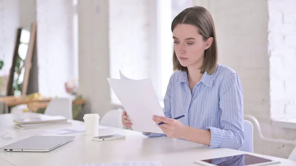 Hårt arbetande unga kvinna Läsdokument i Office — Stockfoto