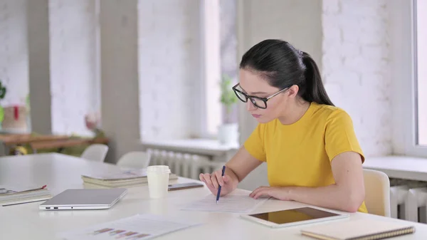 Joven diseñadora escribiendo en papeles en la oficina — Foto de Stock