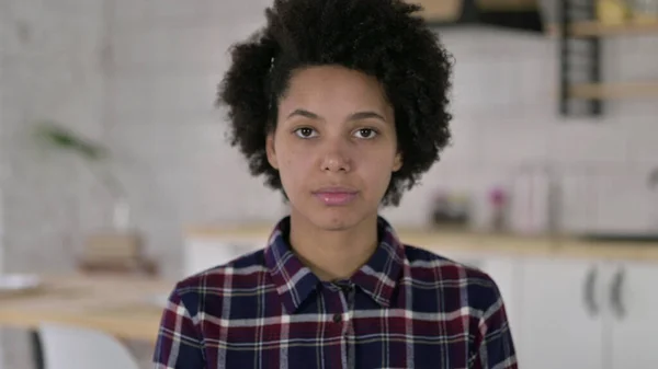 Das Porträt einer Afroamerikanerin, die in die Kamera blickt — Stockfoto