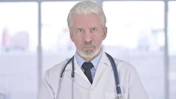 Porträt eines seriösen alten Arztes beim Videochat — Stockfoto