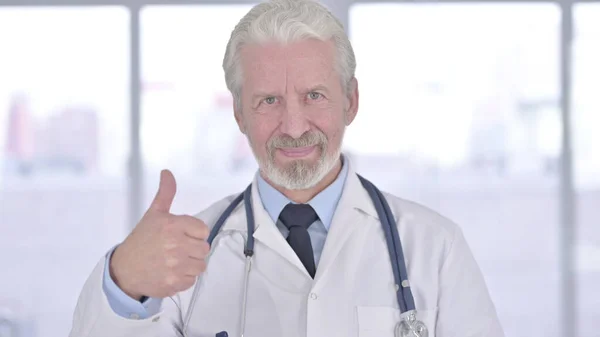 Retrato do velho médico sênior mostrando polegares para cima — Fotografia de Stock