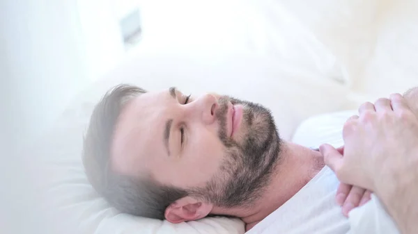 Мирный бородатый молодой человек спит в постели — стоковое фото