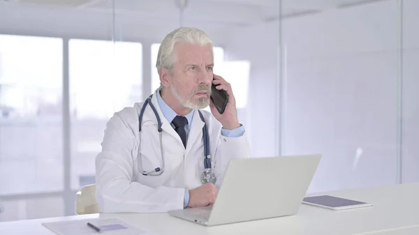 Ευτυχισμένος πρεσβύτερος γιατρός μιλάει στο έξυπνο τηλέφωνο — Φωτογραφία Αρχείου