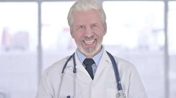 Retrato del viejo doctor sonriente mirando a la cámara — Foto de Stock