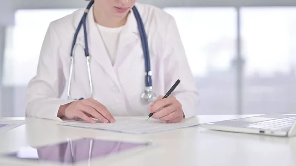 Genç Doktor 'un ofiste evrak işlerini yaparken yakın plan.