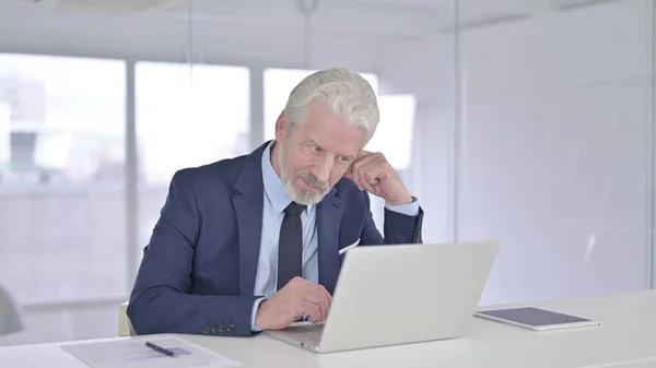 Vieux homme d'affaires Penser et travailler sur ordinateur portable — Photo
