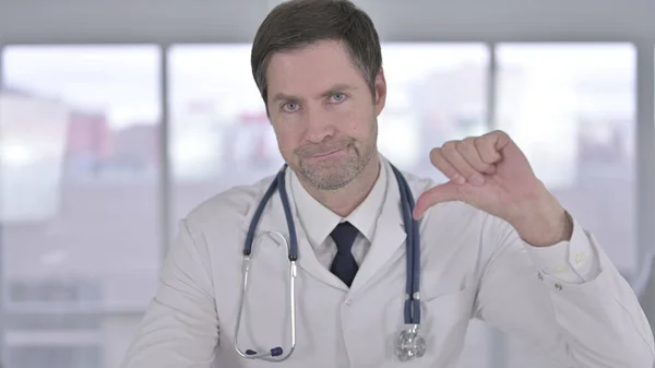 Retrato del médico de mediana edad mostrando pulgares hacia abajo — Foto de Stock