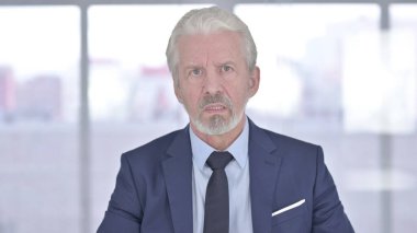 Video sohbeti yapan kızgın yaşlı iş adamının portresi