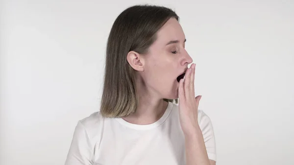 Молода жінка позіхає і напружує тіло на білому фоні — стокове фото
