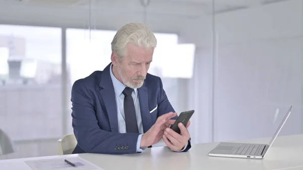 Homme d'affaires concentré utilisant Smartphone dans le bureau moderne — Photo