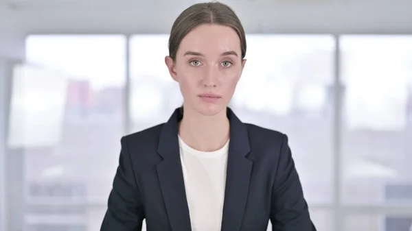 Portret van jonge zakenvrouw kijkend naar de camera — Stockfoto