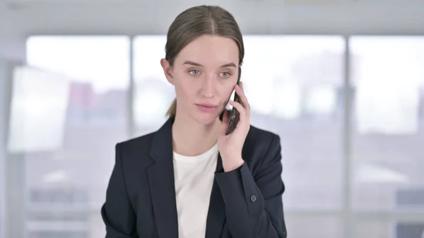 Porträt einer fröhlichen jungen Geschäftsfrau, die mit dem Smartphone spricht — Stockfoto