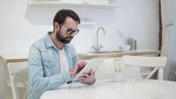 Jeune homme barbe focalisée utilisant une tablette — Photo