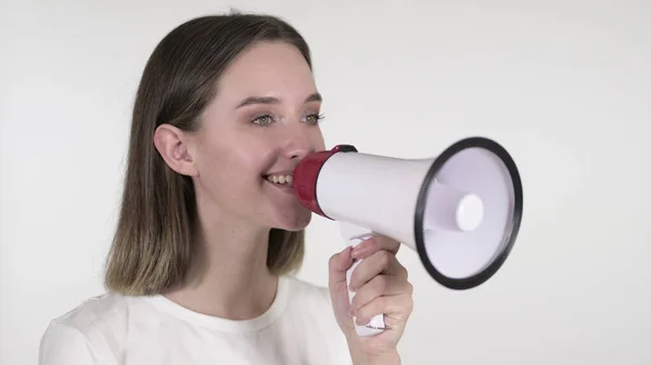 Anunciando jovem mulher gritando através de um megafone, fundo branco — Fotografia de Stock