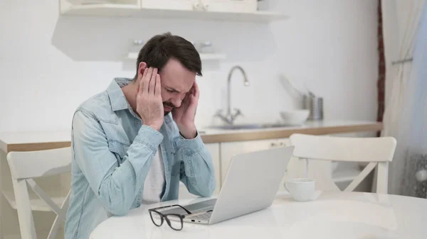 Fleißiger junger Mann mit Bart hat Kopfschmerzen — Stockfoto