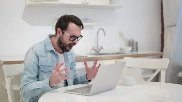 Úzkostlivý vousy mladý muž dostat vztek na notebook — Stock fotografie