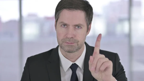 Портрет среднего возраста бизнесмена, говорящего "нет" знаком "Палец" — стоковое фото