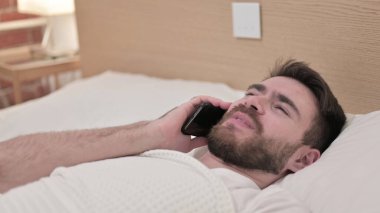 Genç Adam Yatakta Akıllı Telefonla Konuşuyor