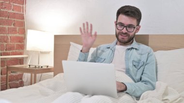 Gözlüklü Genç Adam Laptop 'ta Yatakta Video Sohbeti Yapıyor