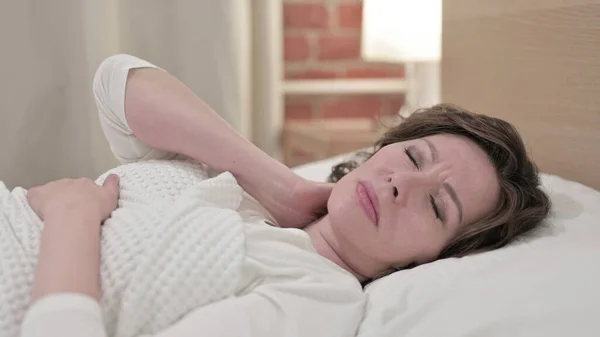 Spící stará žena s bolestí v krku v posteli — Stock fotografie