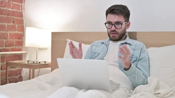 Junger Mann reagiert auf Versagen am Laptop im Bett — Stockfoto