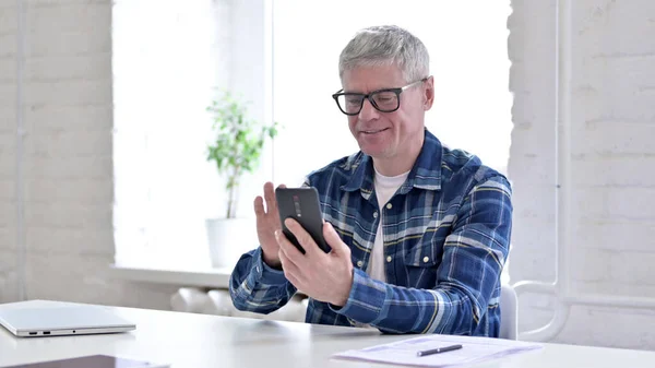 Allegro uomo di mezza età casuale che utilizza smartphone in ufficio — Foto Stock