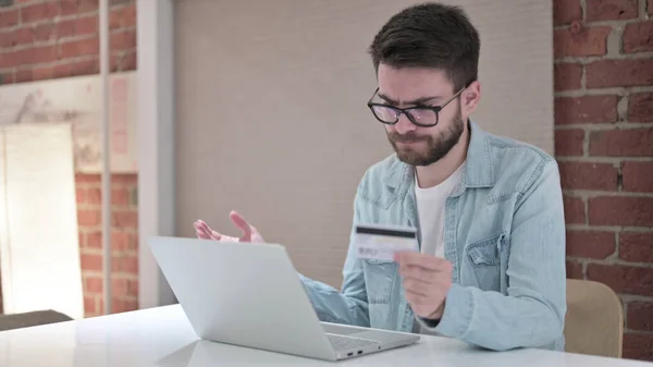 Hombre joven en gafas reaccionando al pago en línea — Foto de Stock