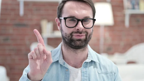 Portrait du jeune homme barbu disant non avec le geste du doigt — Photo