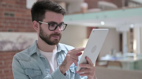 Jovem ambicioso em óculos usando Tablet — Fotografia de Stock