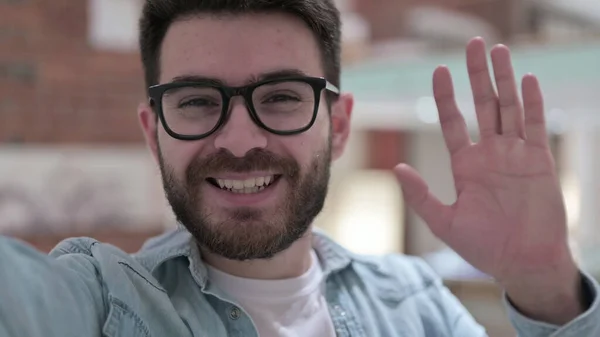 Onnellinen nuori mies lasit tekee Video Chat — kuvapankkivalokuva