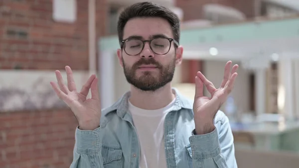 Joven pacífico en gafas meditando —  Fotos de Stock