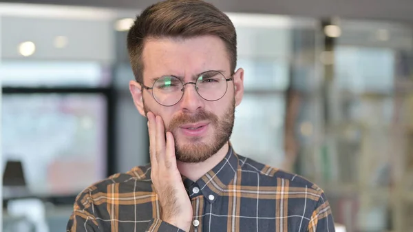 Retrato de un joven diseñador enfermo con dolor de muelas en la oficina — Foto de Stock