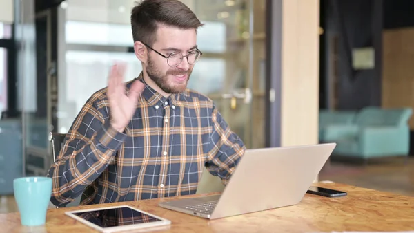 Diseñador joven haciendo Video Chat en el ordenador portátil en la oficina moderna — Foto de Stock