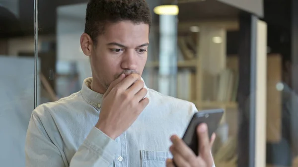 Sad Young African Man Get Shocked by Loss on Smartphone