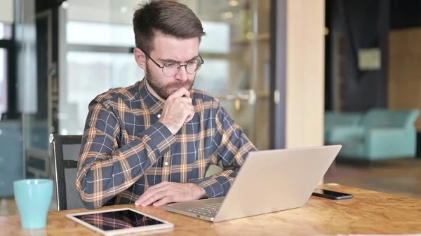 Jovem Designer Pensando e trabalhando em Laptop — Fotografia de Stock