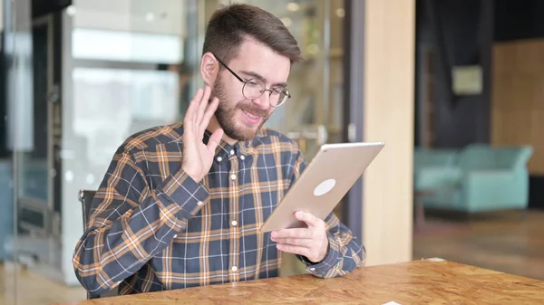 Веселый дизайнер делает видео чат на планшете в офисе — стоковое фото
