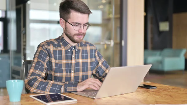 Jovem Designer usando laptop no escritório moderno — Fotografia de Stock