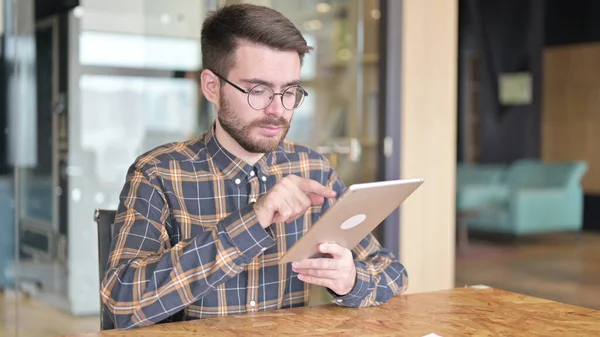 Трудолюбивый молодой дизайнер с помощью планшета в современном офисе — стоковое фото