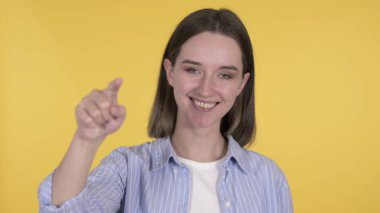 Sarı Arkaplanda Kamerayı Gösteren Genç Kadın