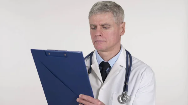Medico senior che legge documenti medici, sfondo bianco — Foto Stock