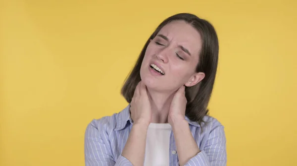 Mulher jovem com dor no pescoço, fundo amarelo — Fotografia de Stock