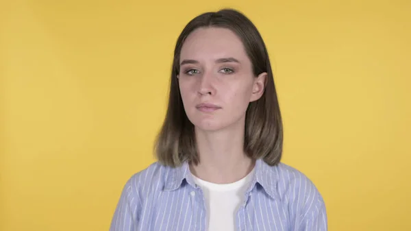 Молодая женщина качает головой, чтобы отрицать на желтом фоне — стоковое фото