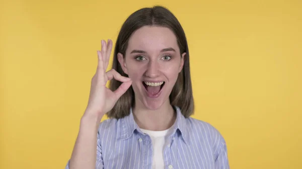 Okay Sign by Mujer joven sobre fondo amarillo — Foto de Stock