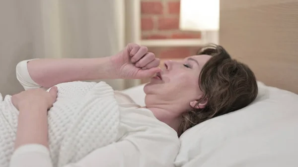 Alvó öregasszony köhög az ágyban — Stock Fotó