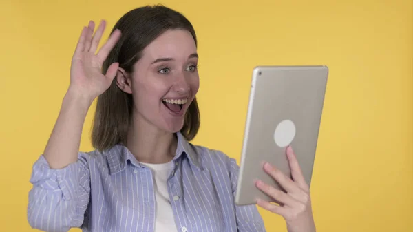 Chat vidéo par Jeune femme via tablette isolé sur fond jaune — Photo